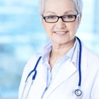 Portrait of pretty female practitioner in eyeglasses looking at camera